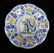 Holland / Netherlands: A Delft porcelain plate decorated with a painting of a woman and tulips c. 1700